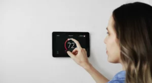 lady adjusting wifi thermostat